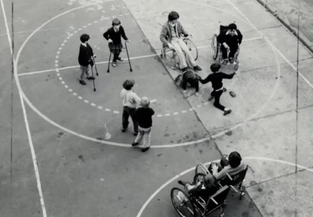 Group of kids on a basketball court, some in wheelchairs and walkers