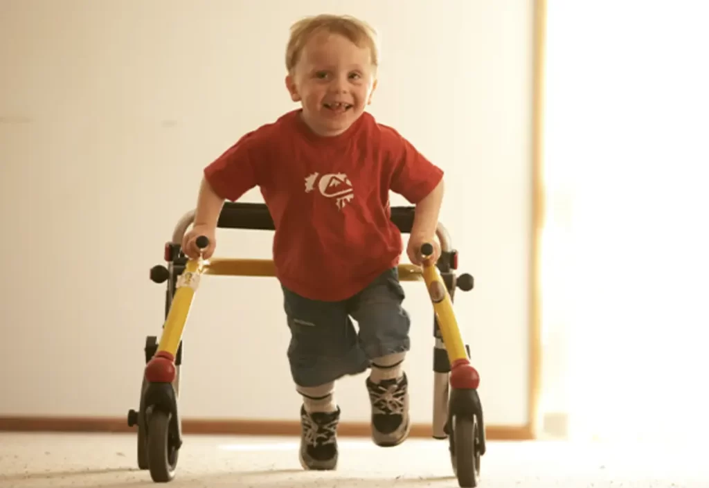 A little boy walking with his walker