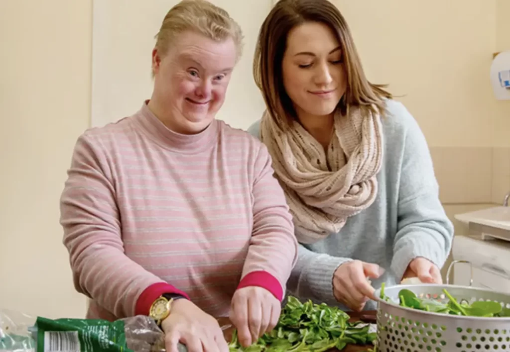 Two people in the kitchen making a salad