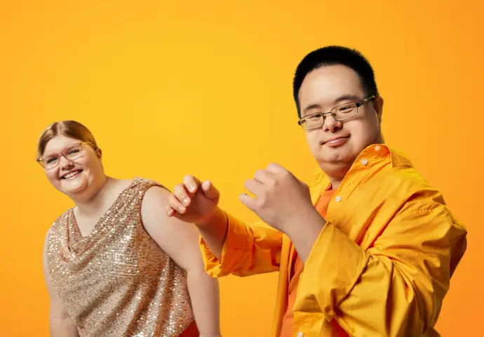 Two people wearing yellow having a bit of a dance